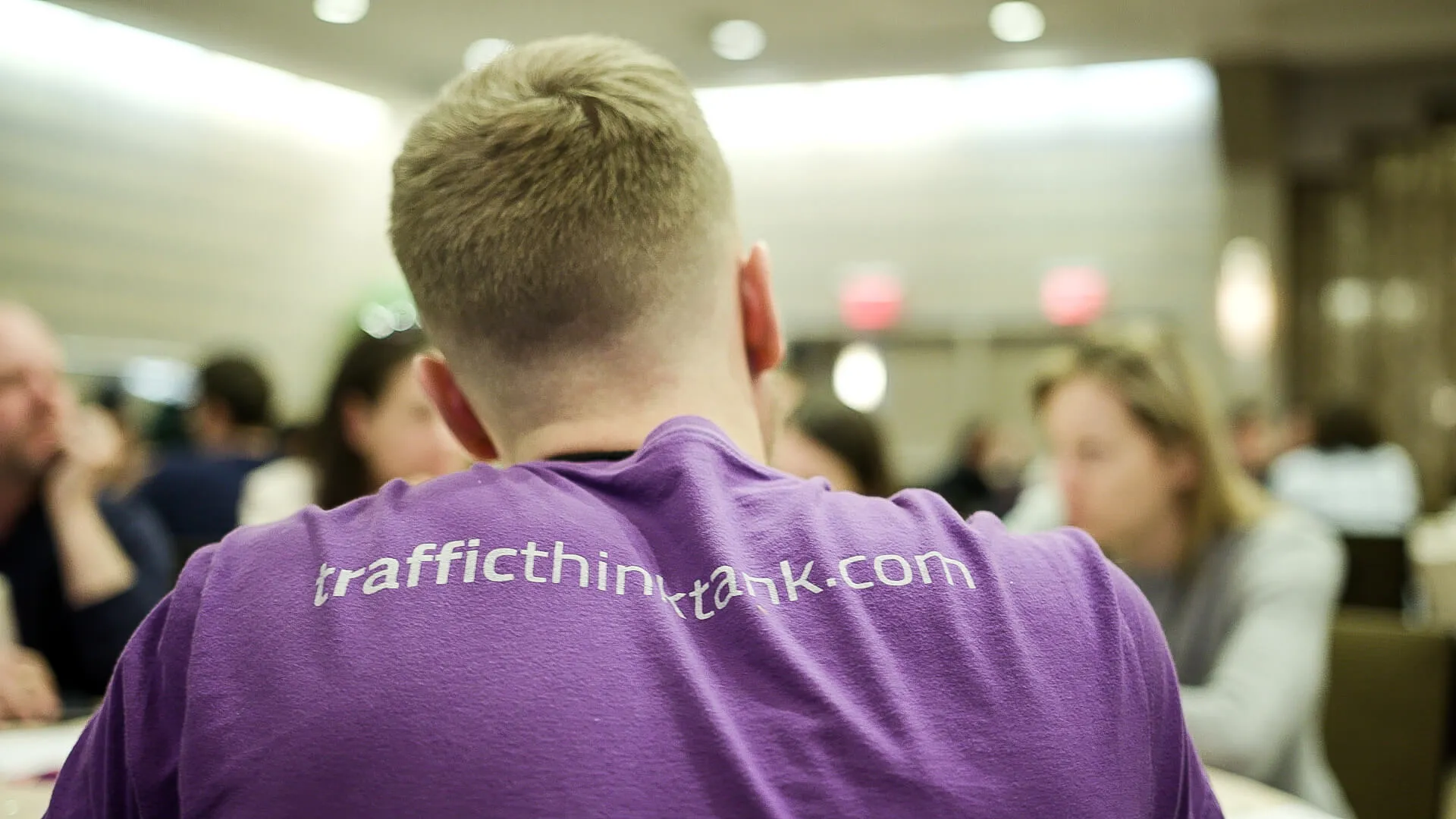 A community member wearing a purple Traffic Think Tank shirt at a live event.