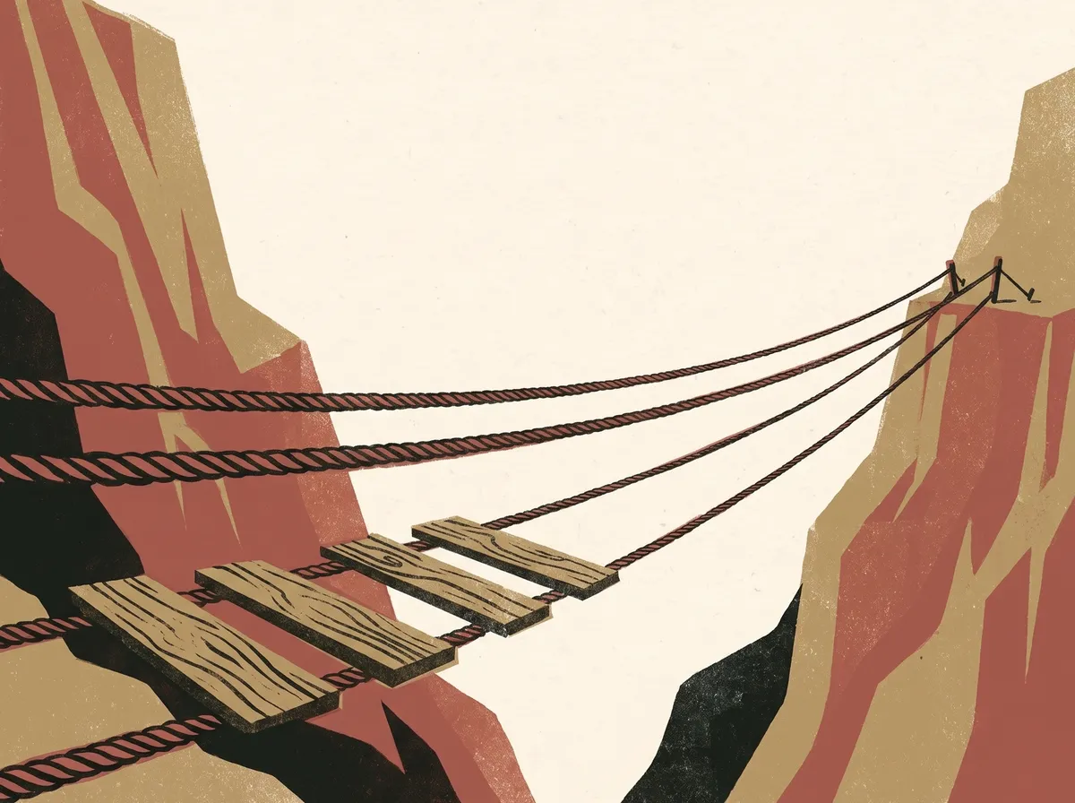 A rope footbridge being built across a gorge, the first few planks laid and the rest still bare rope.