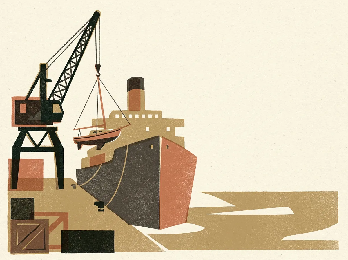 A dockside crane lifting a small sailing dinghy up toward the deck of a freighter.