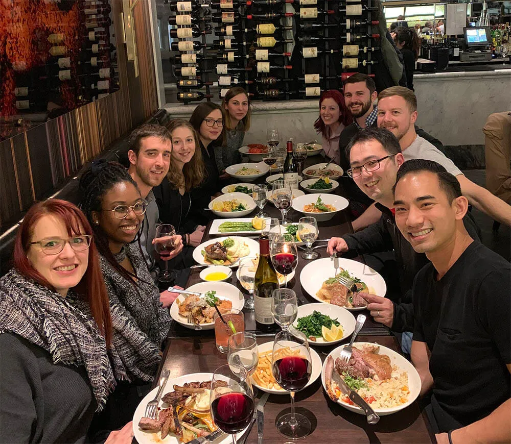 HubSpot colleagues sharing a meal around a long table at a team offsite.